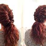 A woman with a voluminous, twisted ponytail hairstyle.