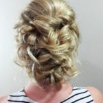 Intricately styled blonde updo with curls and waves.
