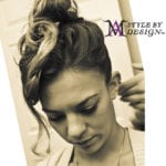 A woman with a stylish updo hairstyle looking downward.