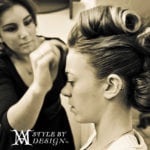 A hairstylist working on a woman's vintage hairstyle.
