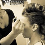 A woman having makeup applied with a brush.