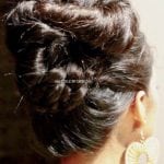 Elegant updo hairstyle with a hairpin accessory.
