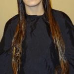 Woman with long, straight, wet hair wearing a black cape.