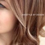 Close-up of a woman's wavy light brown hair and part of her face.