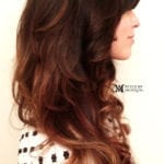 Profile of a woman with long, wavy brown hair.