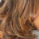 Close-up of wavy brown hair with highlights.