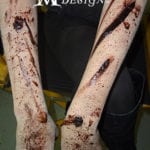 Arms covered in fake blood and wounds for a Halloween costume.
