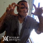 Person with face paint making a claw gesture.