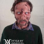 A person with zombie-like face paint and white contact lenses.