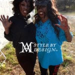 Two women posing outdoors with expressive faces and hands raised.