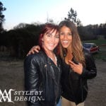 Two women posing outdoors, smiling warmly.