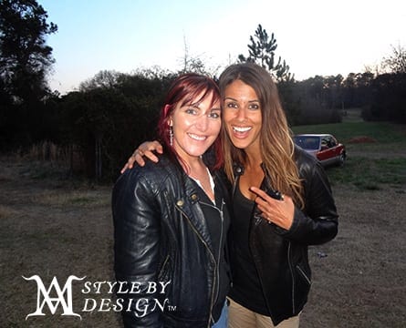 Two women posing outdoors, smiling warmly.