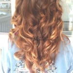 Back view of long, curly brown hair with highlights.