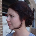 Profile of a woman with dark hair styled in a bun.