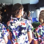 Women in floral dresses standing near mirrors.
