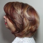 Side profile of a woman with voluminous, layered hair.