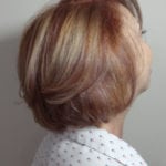 Side view of a short, layered hairstyle with blonde highlights.