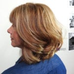 Profile of a woman with shoulder-length layered blonde hair.