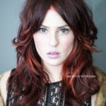 Portrait of a woman with red hair and blue eyes.