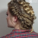 Side view of a woman with a braided hairstyle in a plaid shirt.