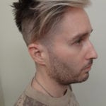 Side profile of a man with a modern haircut and light facial hair.