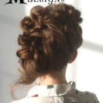 Elegant updo hairstyle with intricate curls and twists on a brunette.