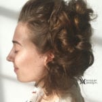 Profile of a woman with curly hair and closed eyes.