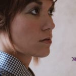 Profile of a woman looking thoughtfully to the side.