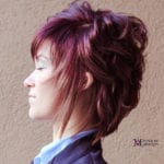 Profile of a woman with layered purple hair styled up.