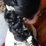 Intricately braided black hair adorned with pearls and a decorative clip.