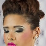 Close-up of a woman with dramatic makeup and an elegant updo hairstyle.