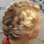 Intricate blonde updo hairstyle with braids.
