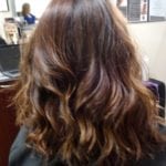 Wavy brown hair styled in loose curls.