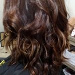A person with shoulder-length wavy brown hair.