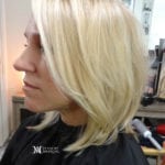 Profile of a woman with shoulder-length blonde hair in a salon.