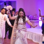 Bride and groom dancing joyfully at their wedding reception.
