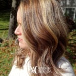 Woman with shoulder-length wavy hair highlighted with blonde and brown tones.