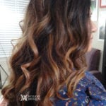 Curly brown hair with highlights.