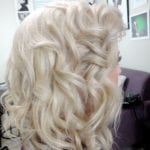 Blonde hair styled in voluminous curls.