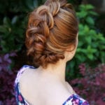 Intricately braided hairstyle on a woman with light brown hair.