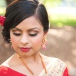 A woman with elegant makeup and jewelry in traditional attire.