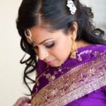 A woman in a purple traditional outfit with intricate embroidery.