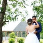 Bride and groom sharing a moment outdoors near a gazebo.