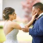 Bride tenderly touches groom's face during wedding ceremony.