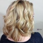 Blonde hair styled in loose curls.