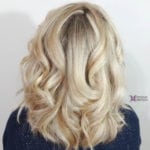 Blonde hair styled in soft, voluminous curls.