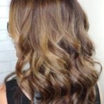 Wavy brunette hair with light brown highlights.