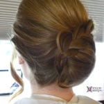 A woman with an elegant braided updo hairstyle.