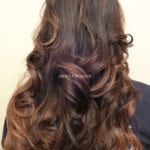 Long wavy brown hair with subtle highlights.