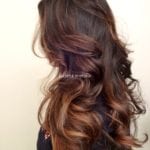 Wavy ombre hairstyle with brown and subtle purple tones.